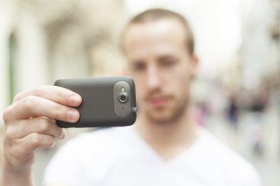 Man holding a cellphone and shooting video