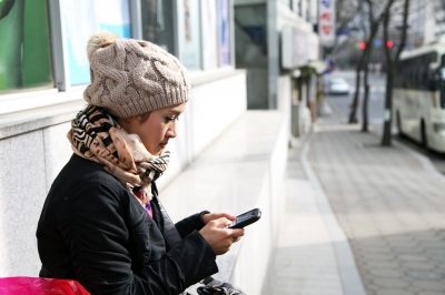 girl on smartphone sitting on bench
